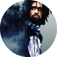 a man with dreadlocks standing in front of smoke