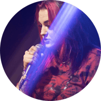 a woman with red hair singing into a microphone